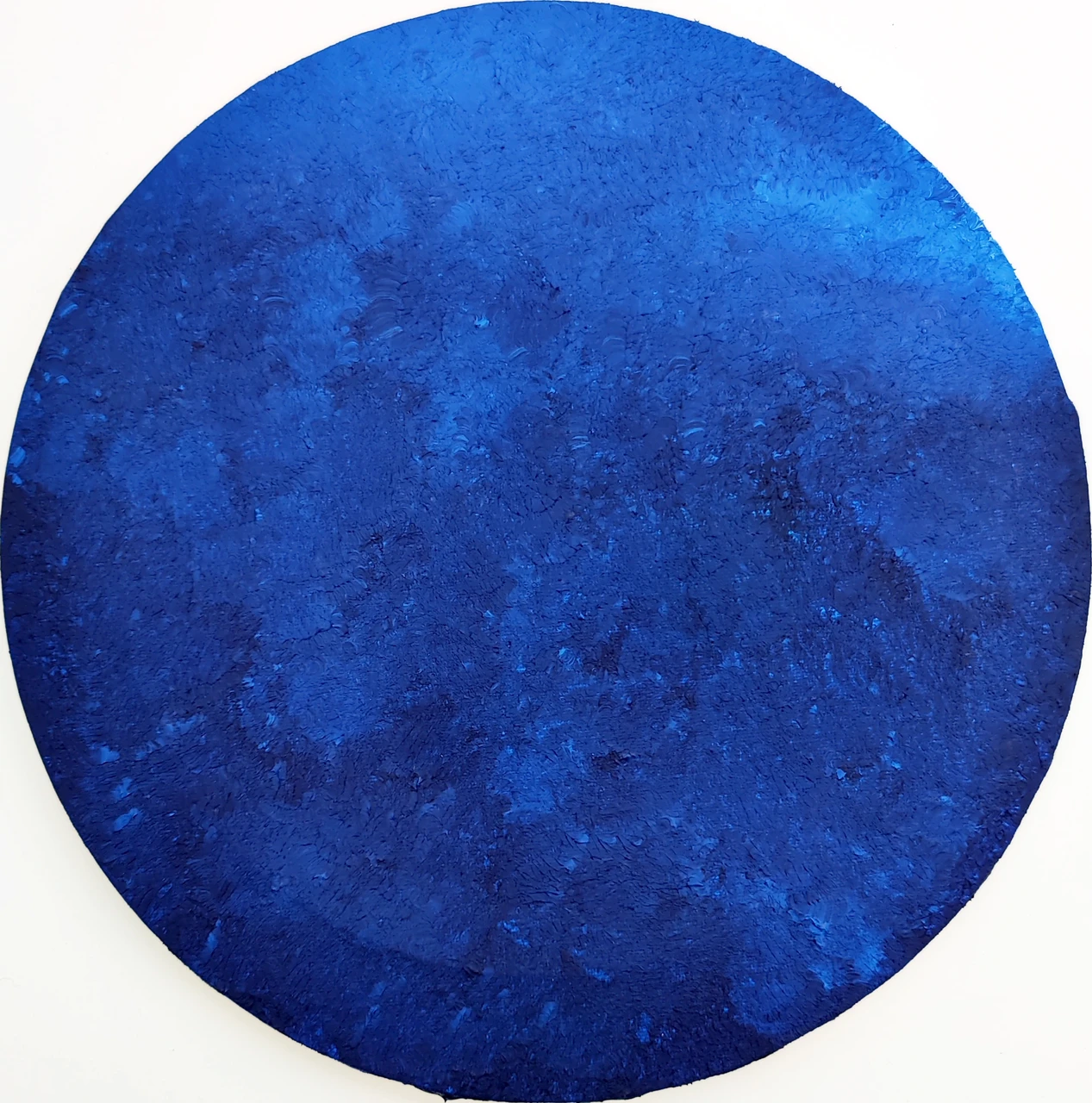 A circular field of cobalt blue, punctuated by a dense, tactile surface.